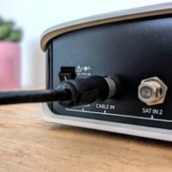 Ansicht auf die Rückseite einer Kabel-TV-Box, die mit einem passendem Kabel angeschlossen ist.